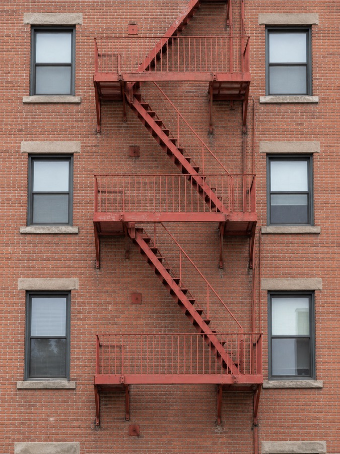 Exterior steel fire escape mounted to a brick building