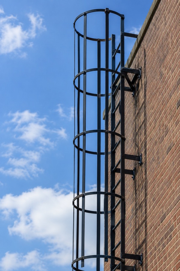 Exterior steel fire escape ladder against the sky