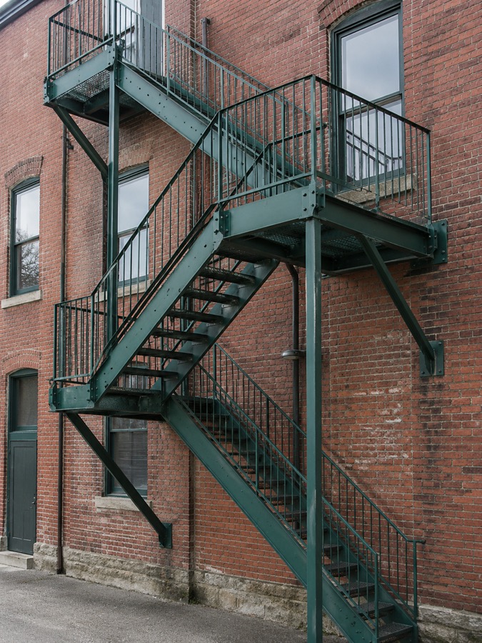 Exterior steel fire escape stairs attached to a brick building