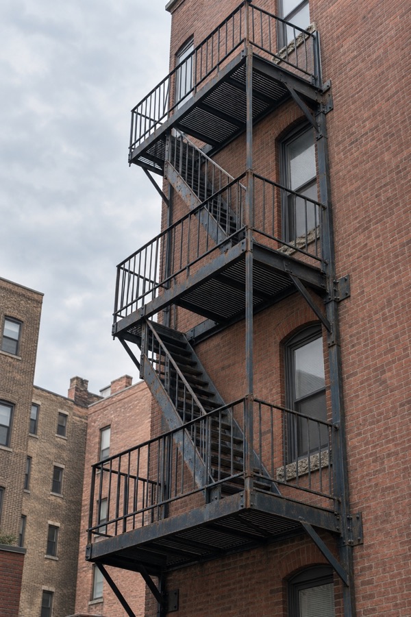 Existing steel fire escape attached to a multistory brick building